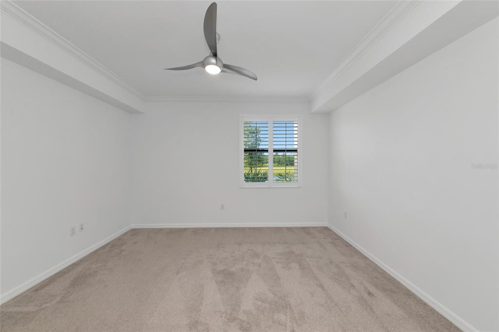 18008 Gawthrop Drive, Unit 101 Lakewood Ranch, FL 34211 - Photo 23 of 56 an empty room with a chandelier fan and windows