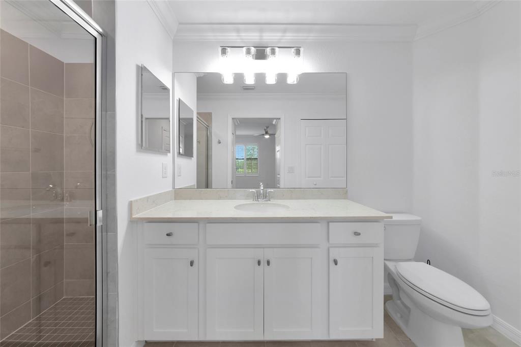18008 Gawthrop Drive, Unit 101 Lakewood Ranch, FL 34211 - Photo 24 of 56 a bathroom with a granite countertop sink a toilet and a mirror
