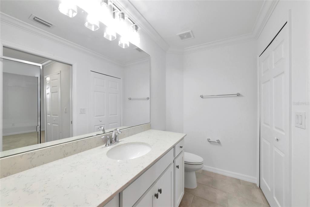 18008 Gawthrop Drive, Unit 101 Lakewood Ranch, FL 34211 - Photo 27 of 56 a bathroom with a granite countertop sink a toilet and a shower