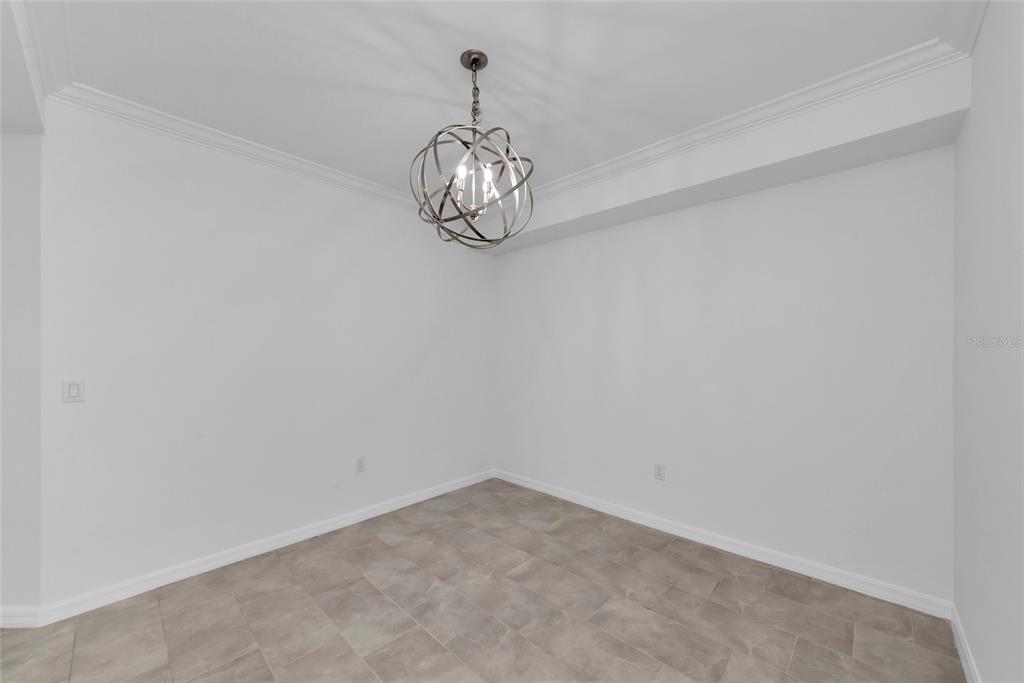 18008 Gawthrop Drive, Unit 101 Lakewood Ranch, FL 34211 - Photo 8 of 56 en empty room with a chandelier fan and wooden floor