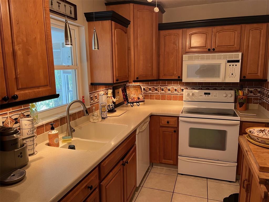 8372 Candlewood Road Seminole, FL 33777 - Photo 6 of 13 a kitchen with a sink stove and cabinets