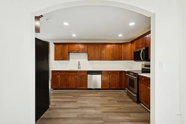 a kitchen with stainless steel appliances granite countertop a stove a sink and a refrigerator