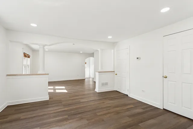 a view of empty room with wooden floor