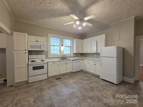a kitchen with white cabinets and white appliances
