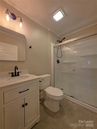 a bathroom with a granite countertop sink a toilet and shower