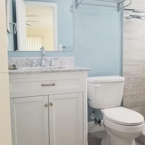 a white toilet sitting next to a shower