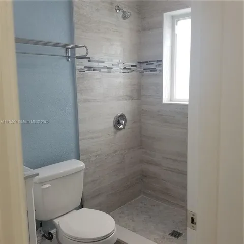 a bathroom with a granite countertop sink a toilet and a mirror
