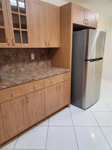 a kitchen with granite countertop a cabinets and a refrigerator