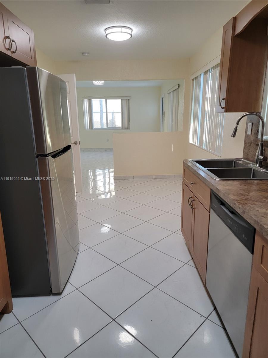 1037 West 23rd Street Hialeah, FL 33010 - Photo 10 of 41 a kitchen with stainless steel appliances granite countertop a refrigerator a sink a stove a microwave a counter top and cabinets