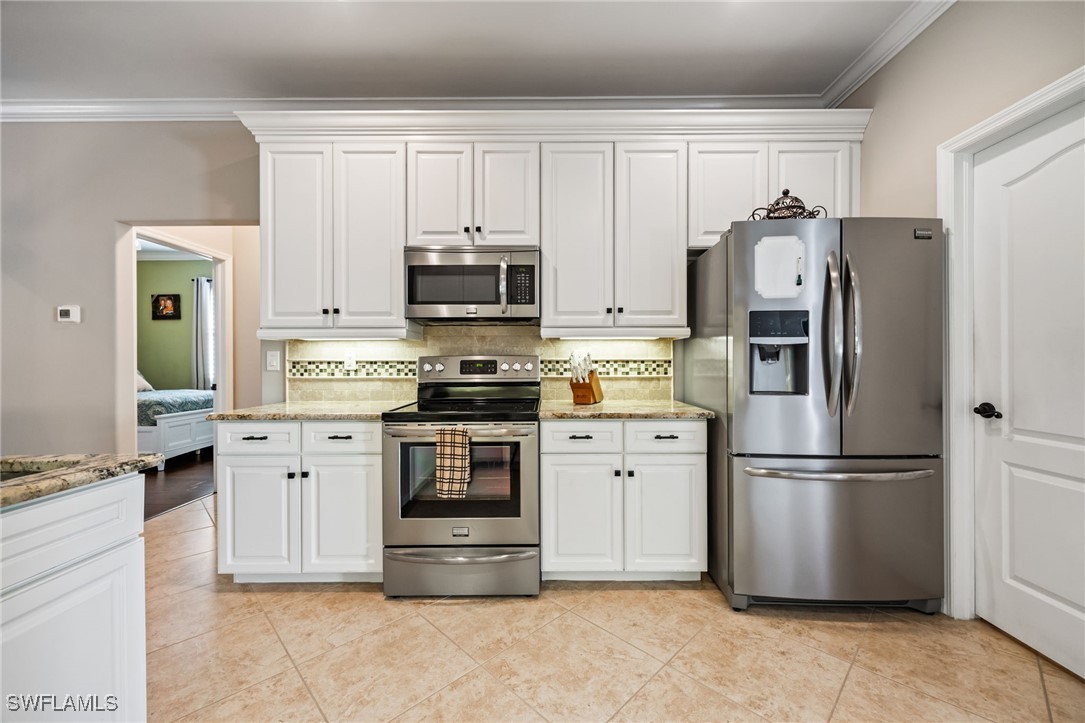 12977 Turtle Cove Trail North Fort Myers, FL 33903 - Photo 17 of 45 a kitchen with stainless steel appliances a refrigerator stove and microwave