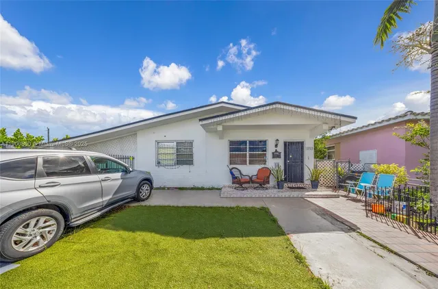 a front view of a house with a garden and patio