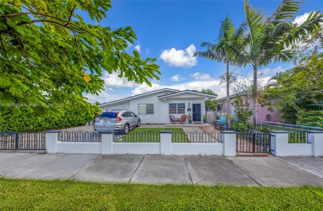 front view of a house with a yard and potted plants