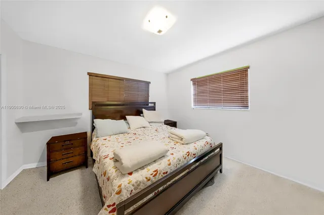 a large bed sitting in a bedroom next to a window