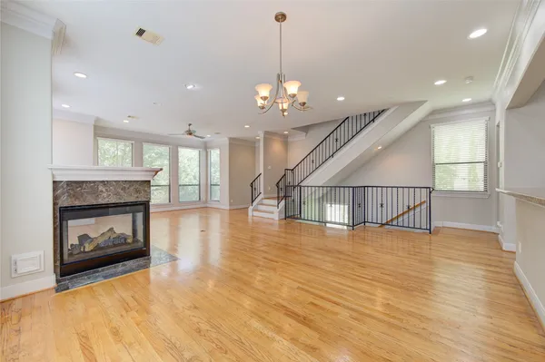 a view of a kitchen and an empty room with wooden floor