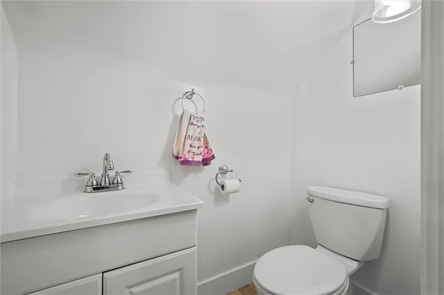 a bathroom with a sink mirror vanity and toilet