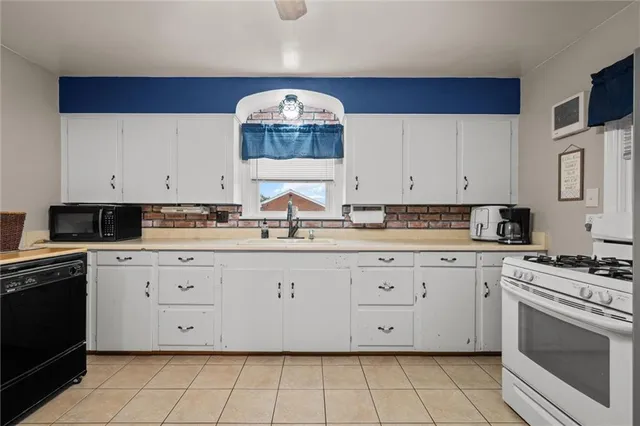 a kitchen with granite countertop white cabinets and white appliances