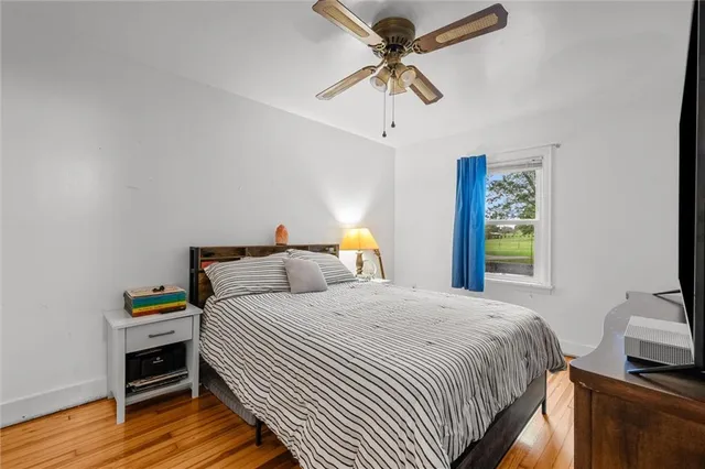 a bedroom with a bed and wooden floor