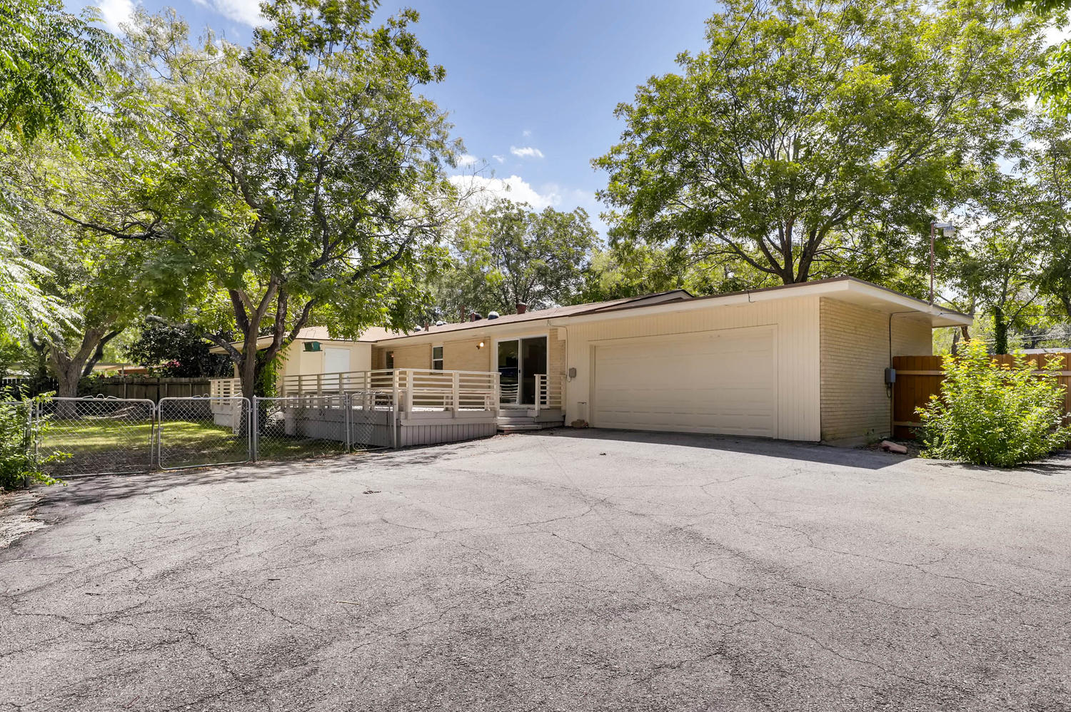 446 Pike Road San Antonio, TX 78209 - Photo 25 of 28 Mature trees frame a charming home with a spacious front deck, integrated garage, and convenient ramp access.