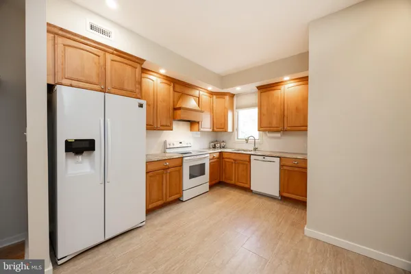 a kitchen with a refrigerator sink and cabinets
