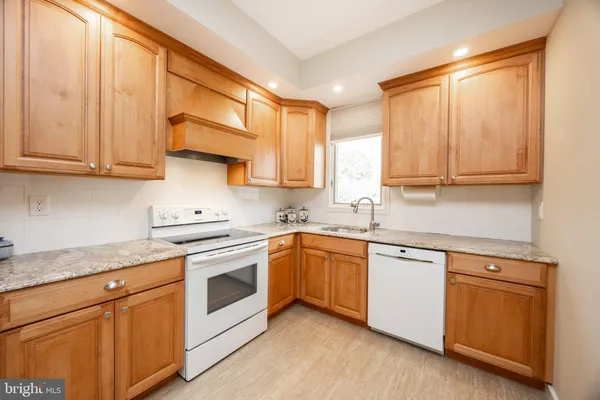 a kitchen with white cabinets sink and appliances