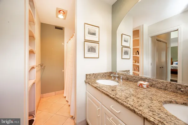 a bathroom with a granite countertop toilet sink and mirror