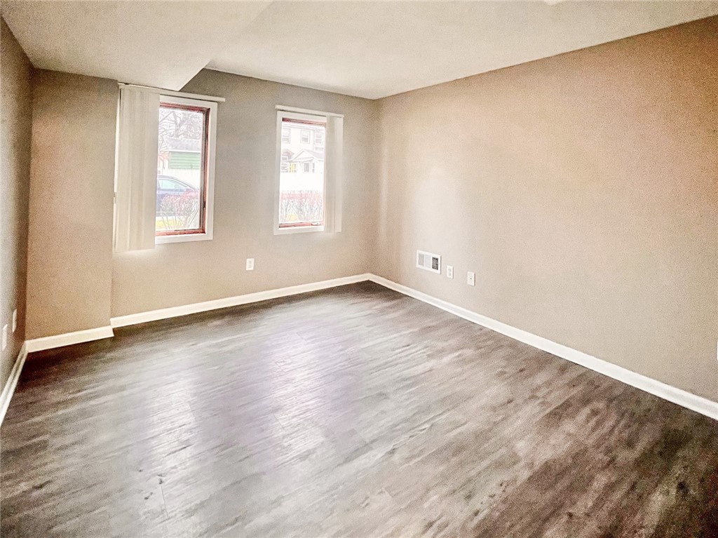 296 South Fitzhugh Street Rochester, NY 14608 - Photo 7 of 9 Typical primary bedroom with faux wood flooring