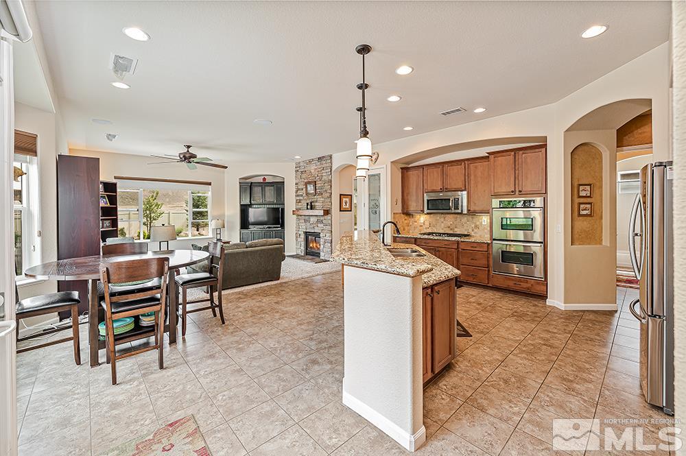 2905 Bull Rider Drive Reno, NV 89521 - Photo 14 of 33 a kitchen with stainless steel appliances kitchen island granite countertop a refrigerator and a stove top oven
