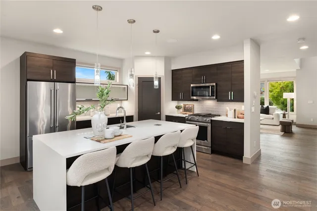 a large kitchen with a table chairs refrigerator and microwave