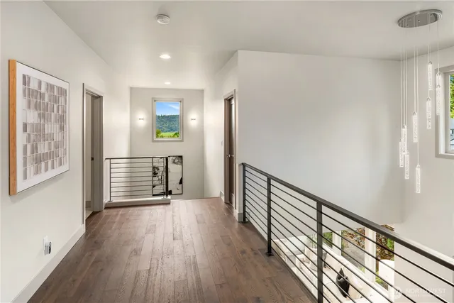 a view of hallway with wooden floor and stairs