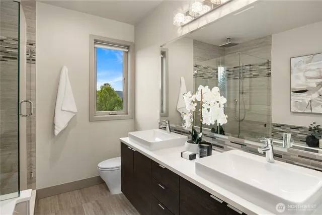 a bathroom with a double vanity sink mirror and toilet