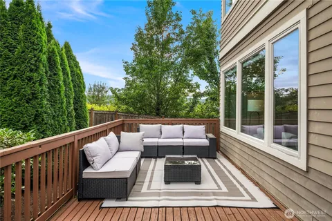 a balcony with wooden floor and outdoor seating