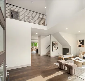 a living room with couches and painting on the wall with wooden floor