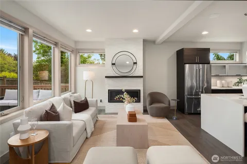 a living room with furniture a fireplace and a large window