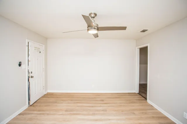 a view of an empty room with wooden floor