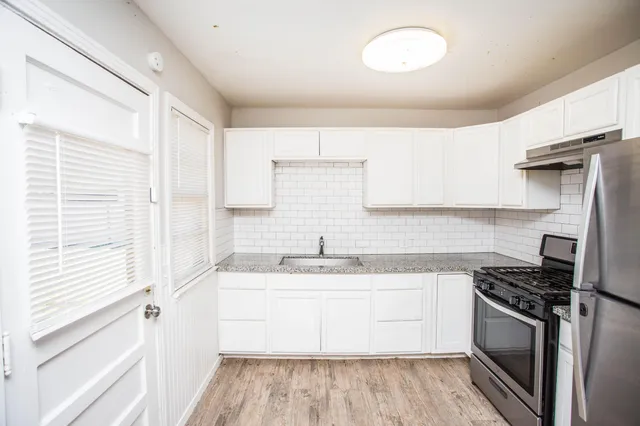 a kitchen with a sink stove top oven and cabinets