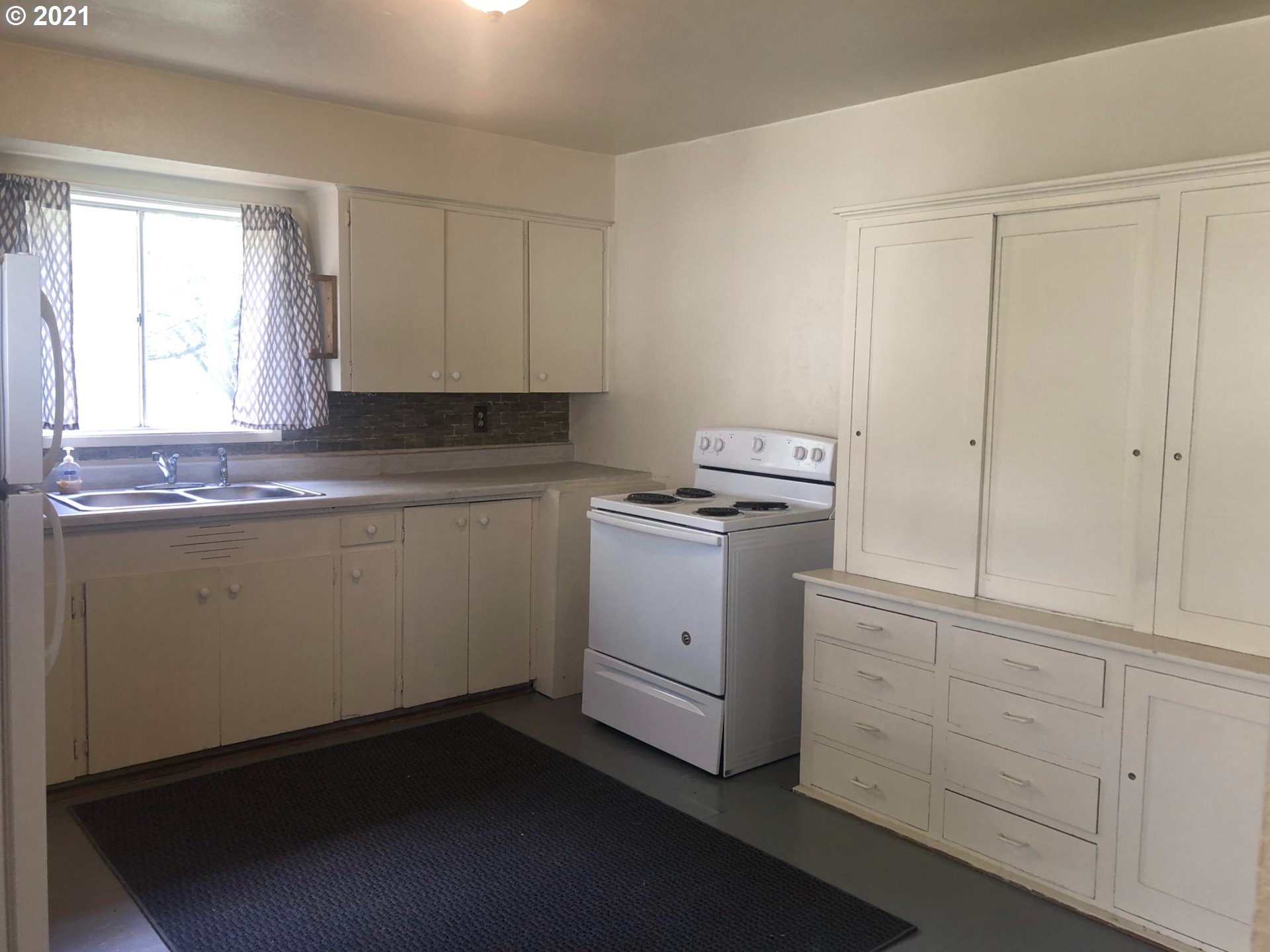 602 South Main Street Pendleton, OR 97801 - Photo 6 of 26 a kitchen with white cabinets and white appliances