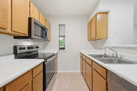 a kitchen with stainless steel appliances granite countertop a sink stove and microwave