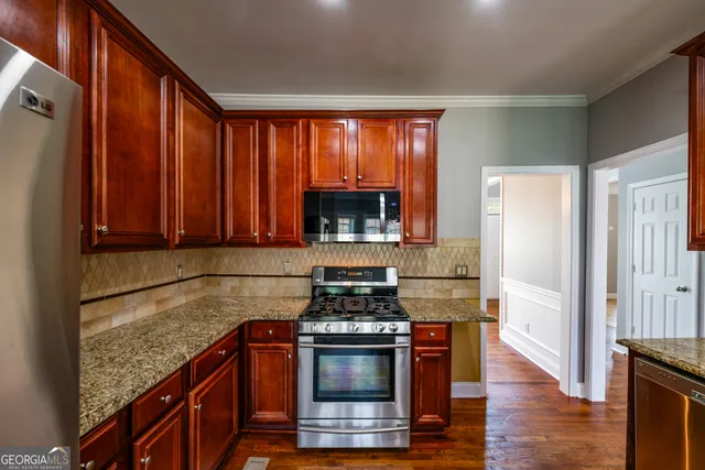 a kitchen with granite countertop a stove and a wooden floors