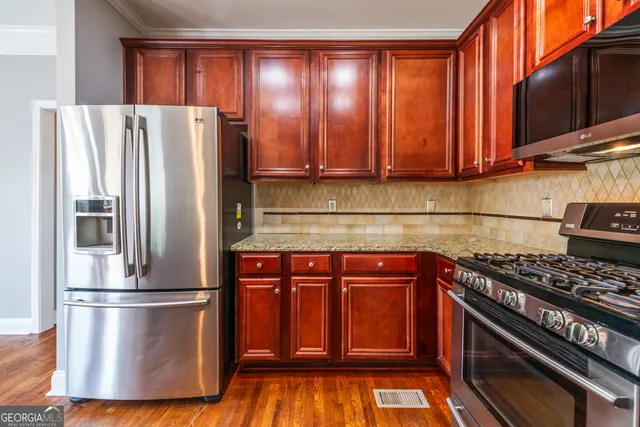 a kitchen with stainless steel appliances granite countertop a refrigerator and a stove top oven