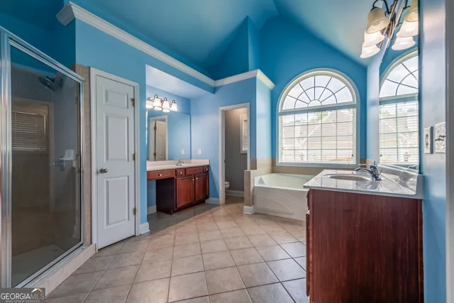 a spacious bathroom with a granite countertop sink a large mirror a bathtub and next to a window