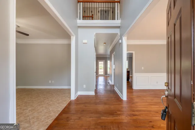 a view of a hallway with wooden floor and staircase