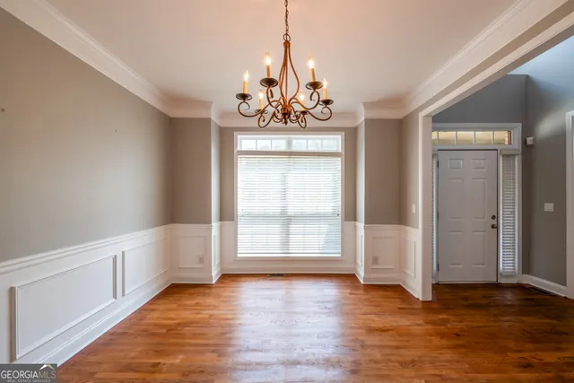 a view of an empty room with window and wooden floor