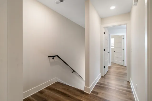 a view of a hallway with wooden floor and staircase