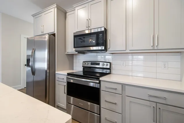 a kitchen with white cabinets and stainless steel appliances