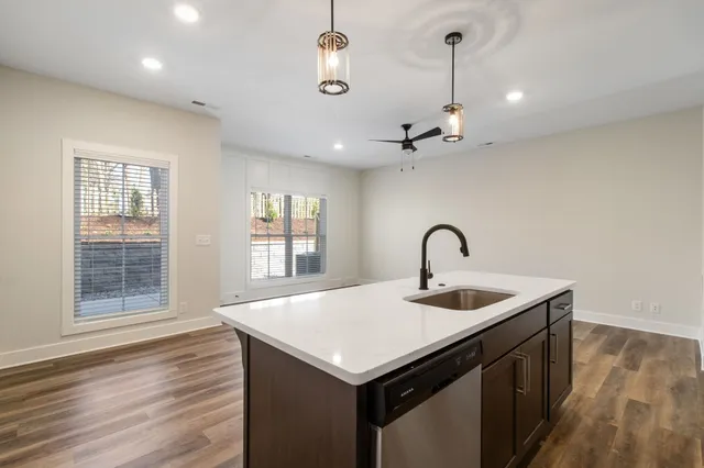 a view of entryway with kitchen island a sink wooden floor and a window