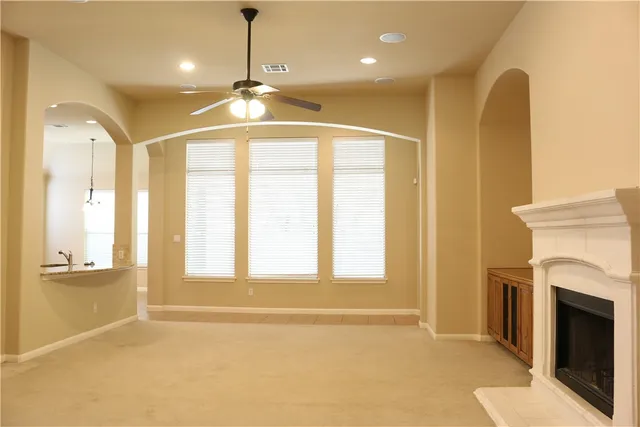 a view of an empty room with a fireplace and a window