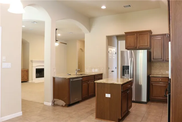 a kitchen with stainless steel appliances granite countertop a refrigerator and a refrigerator