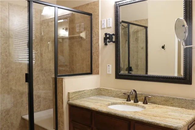 a bathroom with a granite countertop sink and a mirror