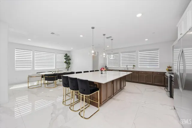 a kitchen with a dining table chairs and a refrigerator