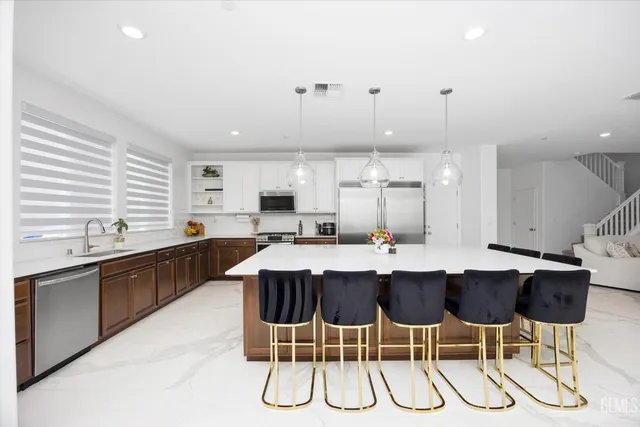 a kitchen with a sink and chairs